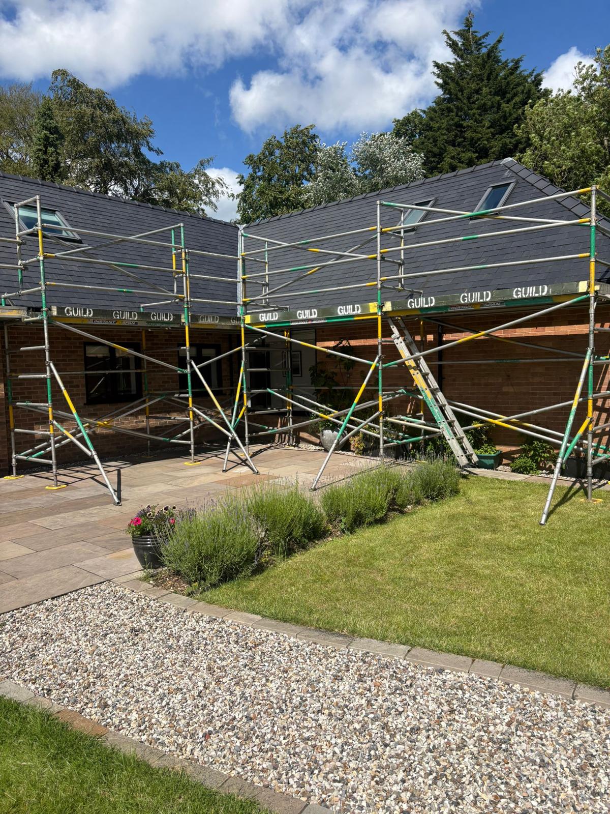Single-storey bungalow with dark slate roof, large patio, full Guild wrap
